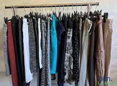 beaucoup de vêtements suspendus à une étagère dans une pièce