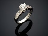 a diamond and white gold ring on a black surface