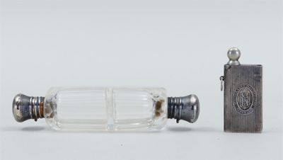 une petite bouteille en verre avec un briquet à côté