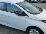 a small white car parked in a parking lot