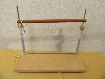 un objet en bois et en métal posé sur une table recouverte d'un tissu jaune