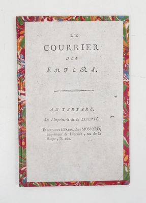 un gros plan d'un livre posé sur une surface blanche, avec une bordure rouge
