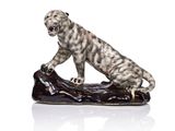 une image représentant une figurine de léopard posée sur une bûche