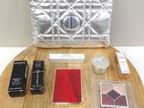 une table sur laquelle se trouvent un sac à main, un rouge à lèvres et d'autres objets