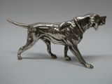 figurine de chien en métal argenté sur fond blanc
