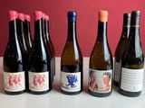 six bouteilles de vin sont alignées sur une table