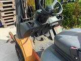 a fork lift truck parked in front of a pile of pallets