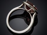a close up of a ring with a red stone on a black surface