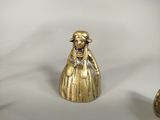 brass figurine of a woman with a hat and dress
