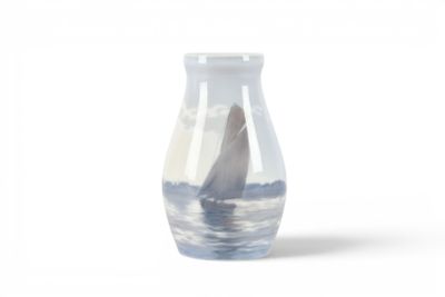 un petit vase avec un voilier dans l'eau