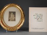 a picture of a picture of a man in a gold frame next to a book