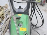 un bidon vert et noir posé par terre à côté d'un tas d'outils