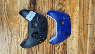 deux manettes de jeux vidéo posées sur une table en bois