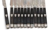 six knives and a knife holder on a white surface