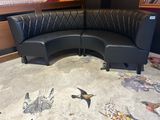 a black leather couch sitting on a rug in a room