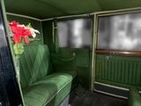 a green couch in the back of a car with a vase of flowers on the seat