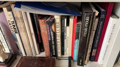 une bibliothèque sur laquelle se trouvent de nombreux livres et une horloge