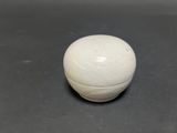 a white ball sitting on a table with a black background