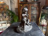 a statue of a boy sitting on top of a table