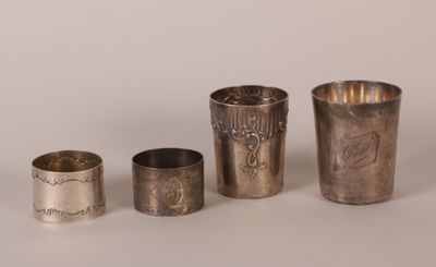three silver cups and a silver spoon on a white surface