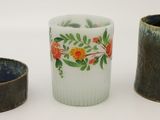 trois vases posés l'un à côté de l'autre sur une surface blanche