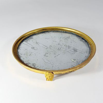 an image of a gold plate with a mirror in the middle of it