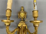 pair of antique brass wall sconces with candles on each of them