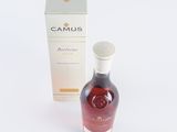 an image of a bottle of brandy next to a box on a white surface