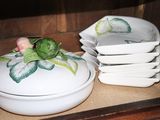 a white bowl with a flower on top of it on a table