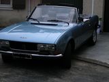 a small blue car parked in front of a house