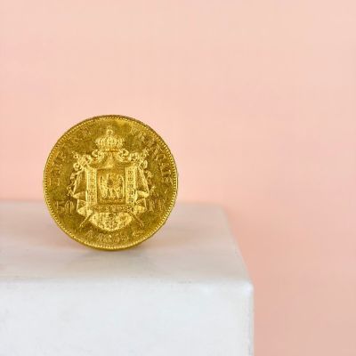 a close up of a gold coin sitting on top of a white pedestal