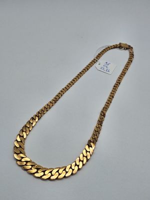 un collier à chaîne en or sur fond blanc
