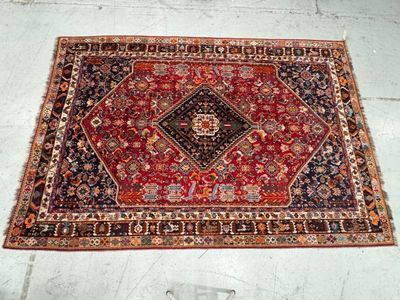 rug on the floor in the middle of a room with a chair