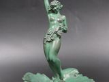 statue of a woman on a leaf holding a cup in her hand
