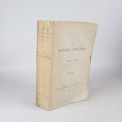 un vieux livre posé sur une table blanche à côté d'un mur blanc