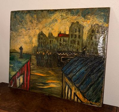 une peinture représentant un paysage urbain posée sur une table en bois