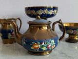 a blue and gold tea set on a marble table