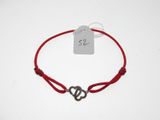un gros plan d'un bracelet en ficelle rouge orné d'un cœur