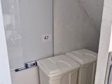two trash cans in the corner of a bathroom