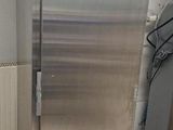 a stainless steel refrigerator in the corner of a room