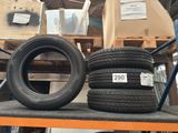 two tires on a shelf in a warehouse with boxes and pallets in the background