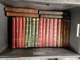 many old books in a metal box on a shelf