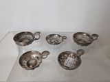 six silver plated bowls and spoons on a glass table