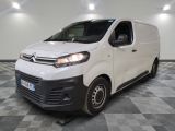 la camionnette blanche est garée dans une grande pièce au sol en damier