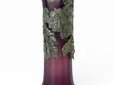 un vase violet orné de feuilles sur fond blanc