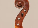 a close up of the back of a violin with a fiddle in the foreground