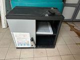 a broken microwave oven sitting on the floor in a kitchen