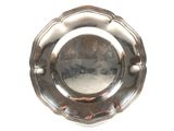 une assiette en argent sur fond blanc, dans laquelle on voit un reflet