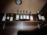 bottles of wine are lined up on a shelf in a dark room
