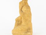 an image of a statue of a man sitting on a rock